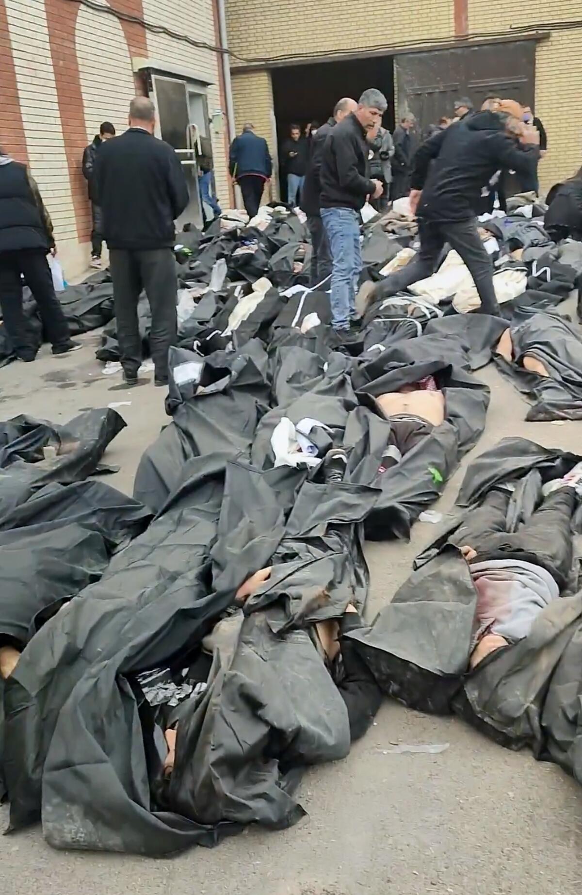 This frame grab shows images from a morgue with dozens of bodies and mourners