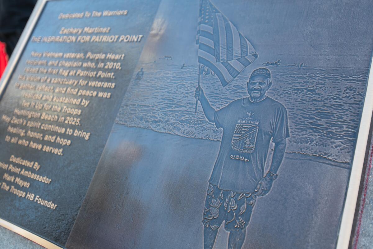 A plaque depicts Zach Martinez, creator of Patriot Point, at the base of a flagpole in Huntington Beach on Saturday.