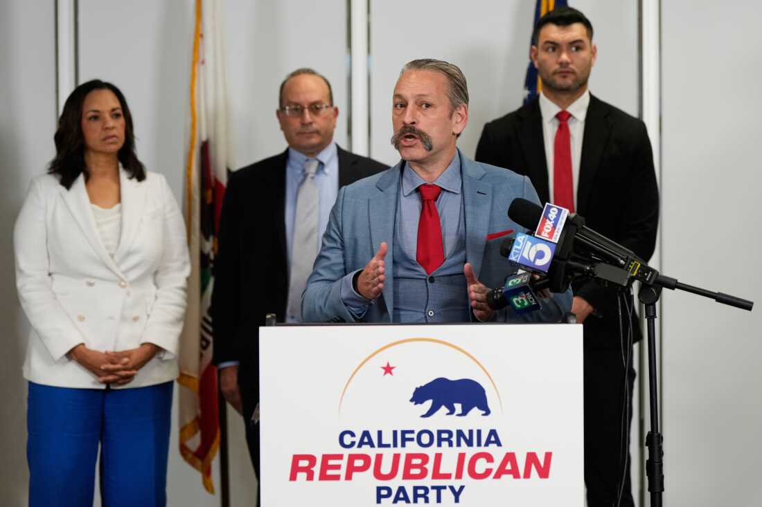 Attorney Mark P. Meuser, second from right, speaks to reporters during a press conference announcing a federal lawsuit challenging Proposition 50, last month in Sacramento, Calif.