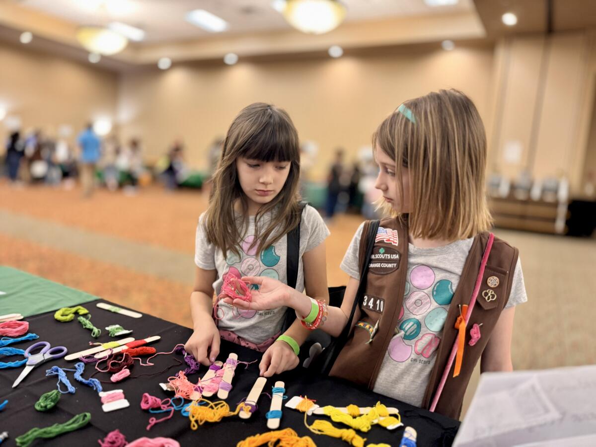 Girl Scouts examine crafting supplies at the Girl Scouts of Orange County Cookie Kickoff on Sunday.