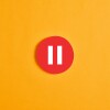 Red round circle with a pause button or icon against yellow background.