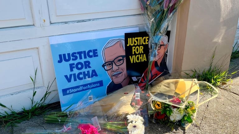 Flowers are left with pictures of 84-year-old Vicha Ratanapakdee during...