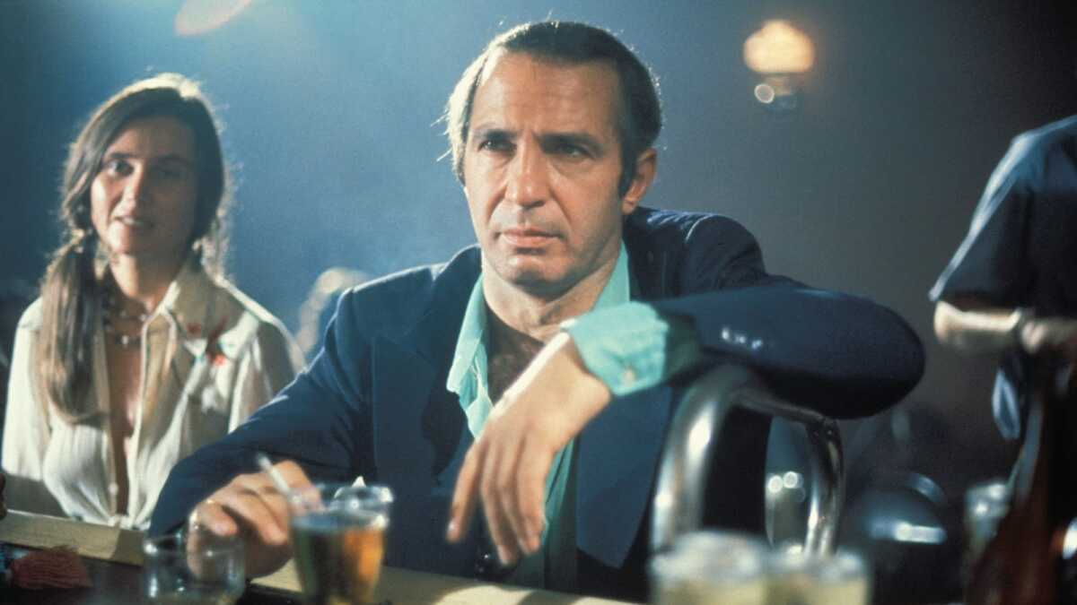 A man has a cocktail at a bar.