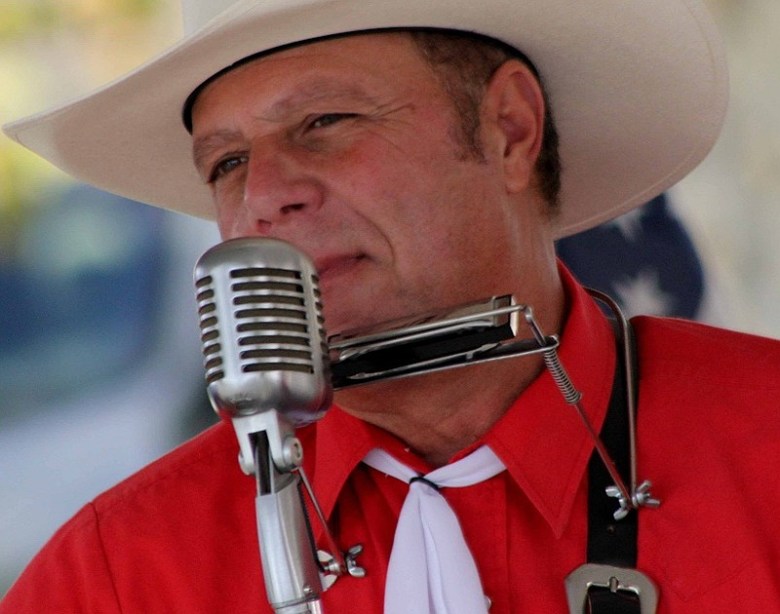 Man in white cowboy hat and western attire singing into microphone. One of six concerts in San Diego this week to check out.