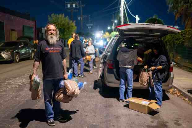 FILE -- Street team volunteer Garret Eiferman with supplies for homeless people on Deering Avenue in Canoga Park on Dec. 18, 2024. LA County's Homeless Services and Housing Department anticipates making cuts to community outreach teams in its upcoming budget. The budget comes before the LA County Board of Supervisors on Feb. 3, 2026. (Photo by Hans Gutknecht, Los Angeles Daily News/SCNG)
