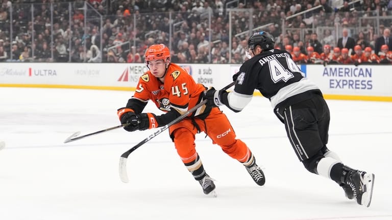 Anaheim Ducks right wing Beckett Sennecke, left, passes the puck...