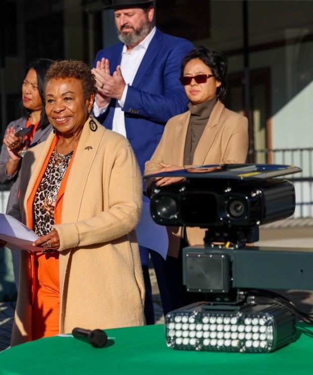 An automated speed safety camera is displayed on a table as Oakland Mayor Barbara Lee walks toward the podium to address the media during a news conference at the intersection of 27th Street and Broadway in Oakland, Calif., on Friday, Jan. 16, 2026. 18 cameras have been installed at locations throughout the city and began issuing warnings on Jan. 14, 2026. They are scheduled to begin issuing speeding tickets in mid-March 2026, according to city officials. (Ray Chavez/Bay Area News Group)