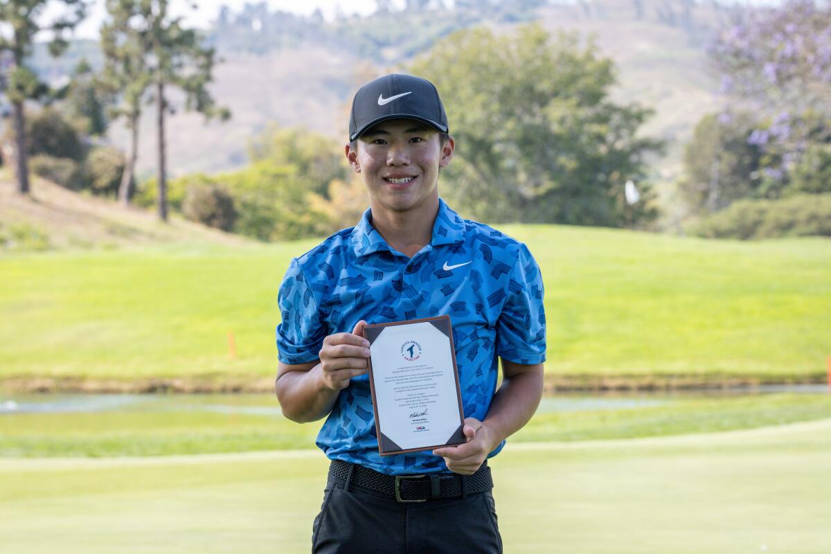 Jaden Soong poses for a photo with the Southern California Golf Assn. Amateur Championship winner's plaque.