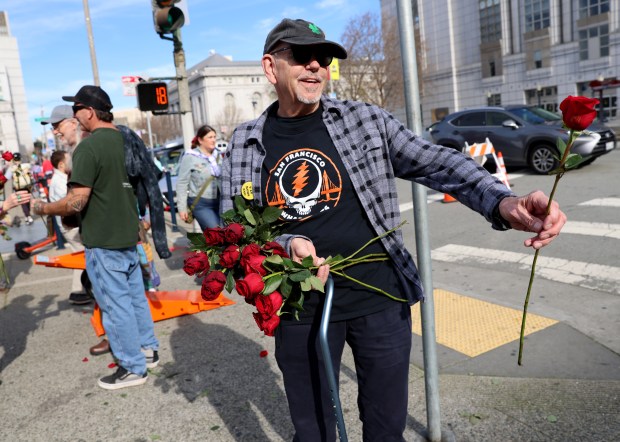 Grateful Dead fan Greg Hansen, of San Rafael, who has attend several hundred shows, hands out roses at the Bob Weir memorial at Civic Center Plaza in San Francisco, Calif., on Saturday, Jan. 17, 2026. Thousands of people gathered to say goodbye to the band's co-founder and guitarist, who passed away on Jan. 10. (Jane Tyska/Bay Area News Group)