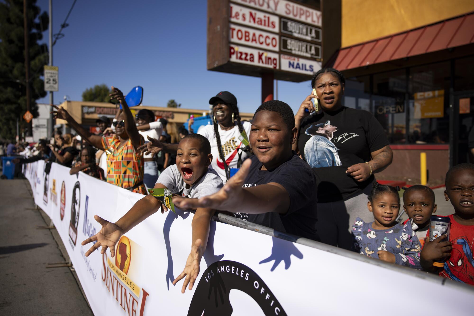 Spectators reach out to grab candy being thrown.