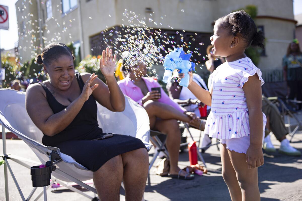Janae Owens plays with bubbles with Alayah Peterson during the Dr. Martin Luther King Jr. Day Parade.