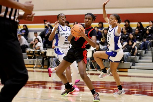 Lakewood freshman Aniyah Lindsey splits the Jordan defense as she controls the basketball in a Moore League battle at Browning High School in Long Beach on Friday, Jan. 16, 2026. (Photo by Howard Freshman, Contributing Photographer)