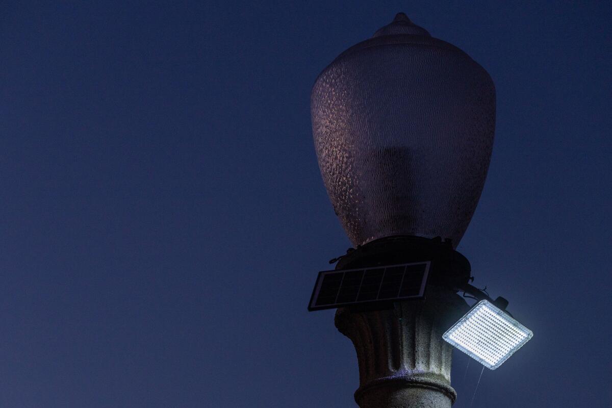 a solar powered light attached to a non-functional street lamp