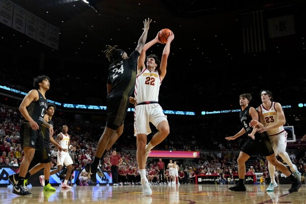 Iowa State forward Milan Momcilovic (22) looks to shoot over Long Beach State guard Christian Jones (24) during the first half of an NCAA college basketball game, Sunday, Dec. 21, 2025, in Ames, Iowa. (AP Photo/Charlie Neibergall)