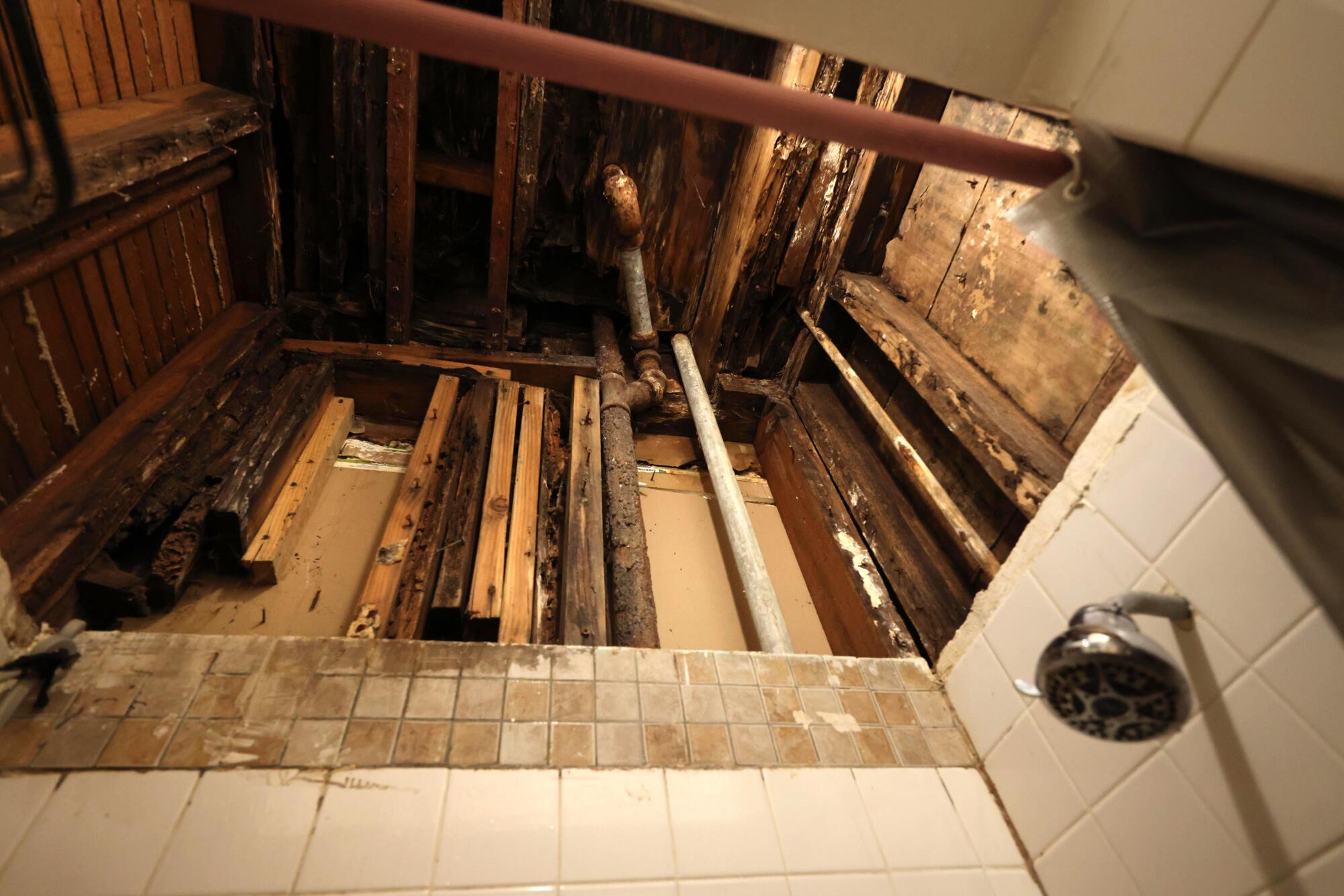 A photo of exposed pipes and beams in a bathroom.
