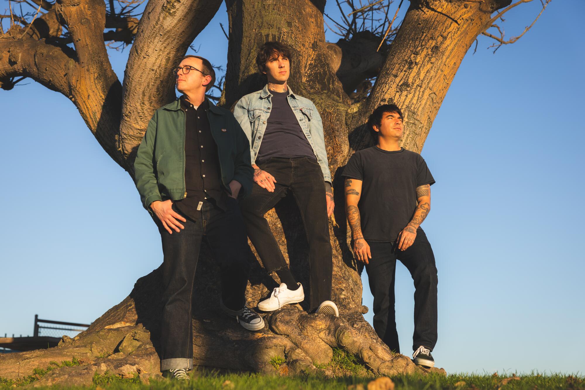 Members of punk rock band Joyce Manor standing against a large tree