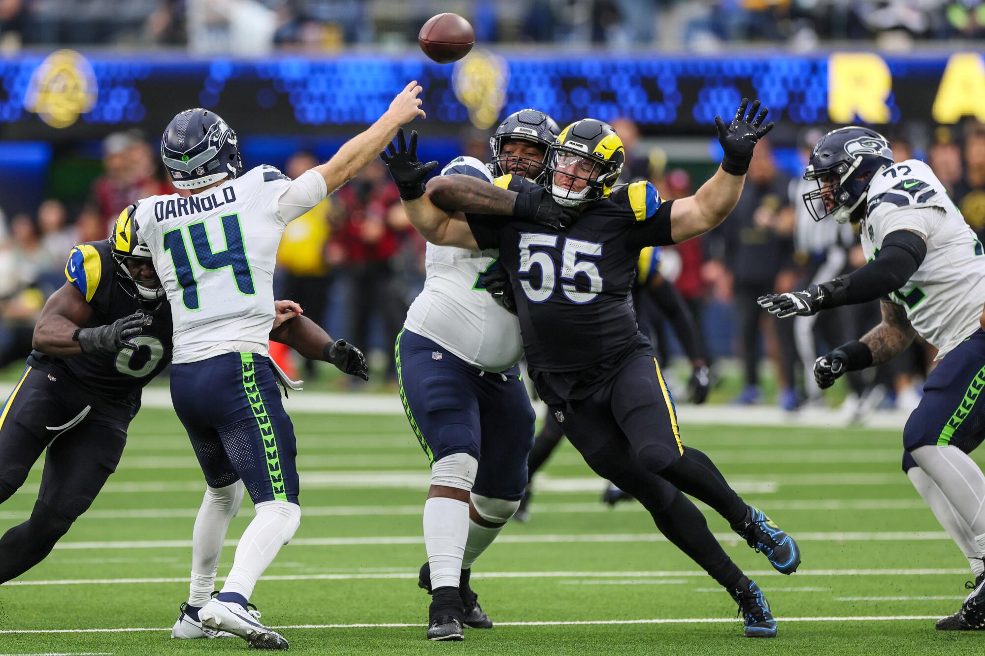 Rams defensive end Braden Fiske and linebacker Byron Young close in on Seattle Seahawks quarterback Sam Darnold.