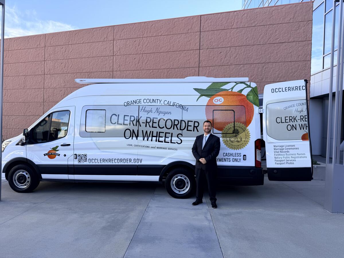 Orange County Clerk-Recorder Hugh Nguyen stands in front of his mobile office van in Santa Ana.