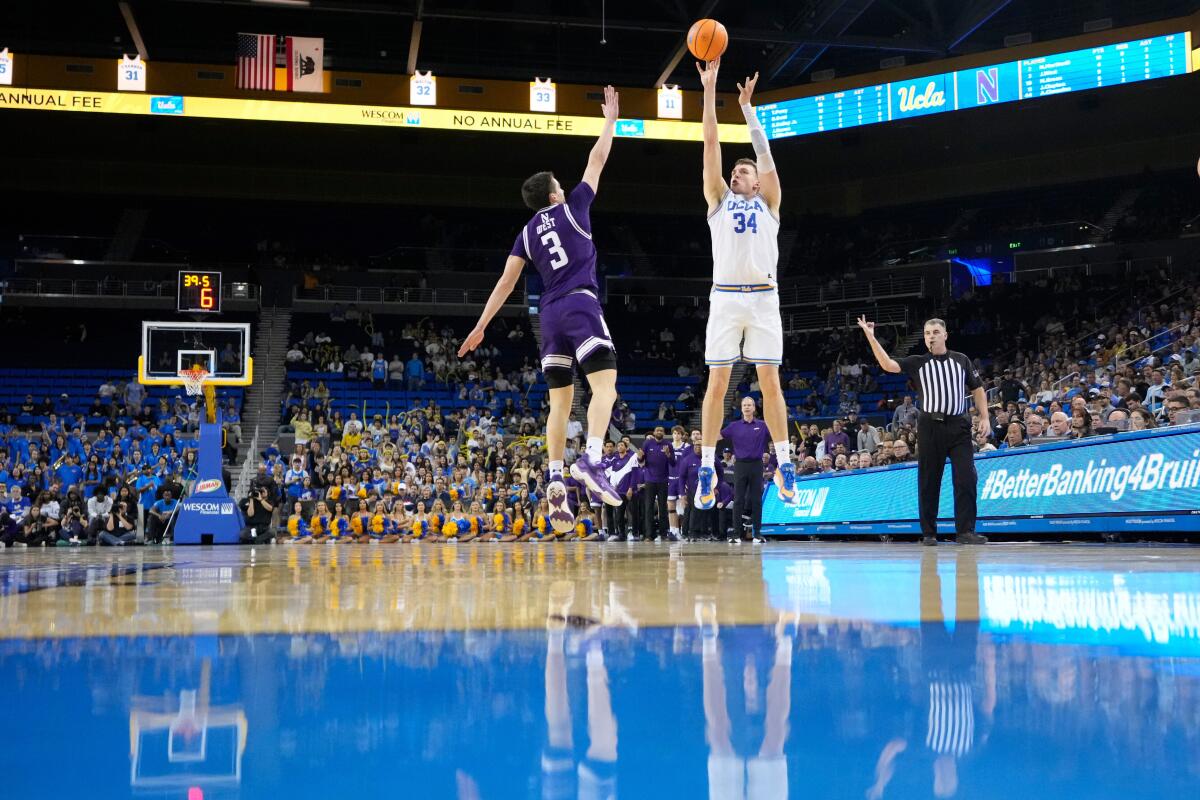 UCLA forward Tyler Bilodeau, right, shoots over Northwestern guard Jake West.