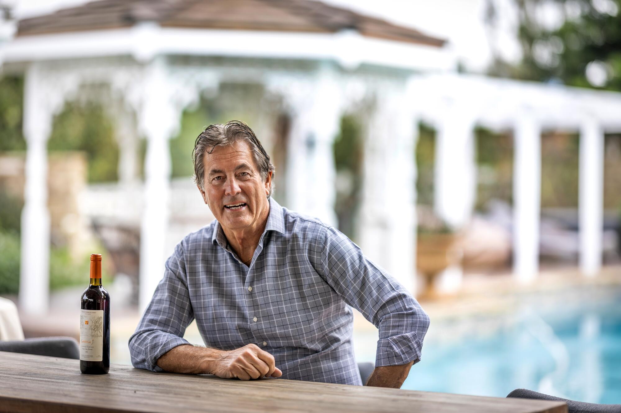 Vince Ferragamo, the first QB to take the Rams to a Super Bowl, is photographed with a bottle of his wine.