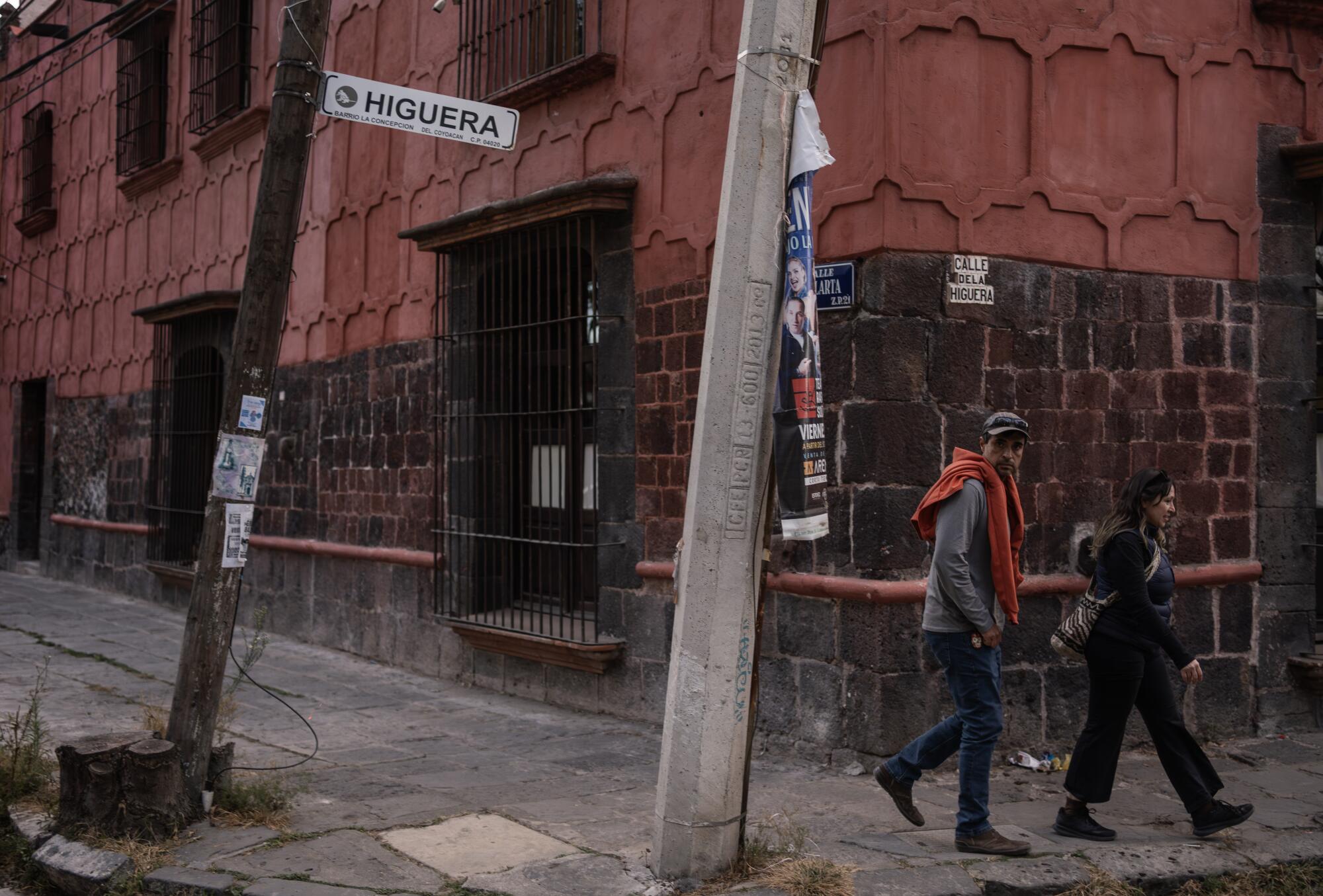 A couple walks past the Casa Colorada in the Coyoacan neighborhood