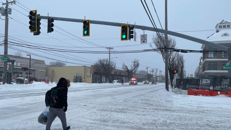  A man walks across Westminster Road at the intersection with Hempstead...