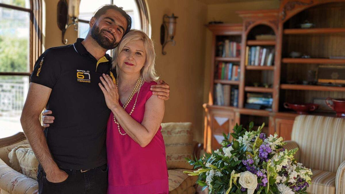 A man and a woman embrace in a living room.