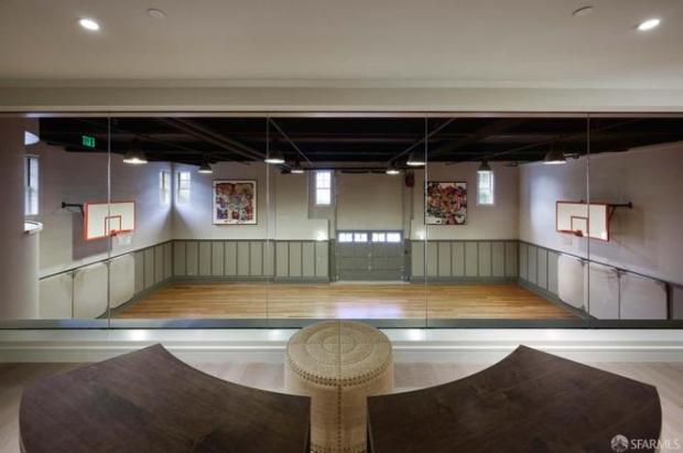 A lounge overlooking a basketball court.