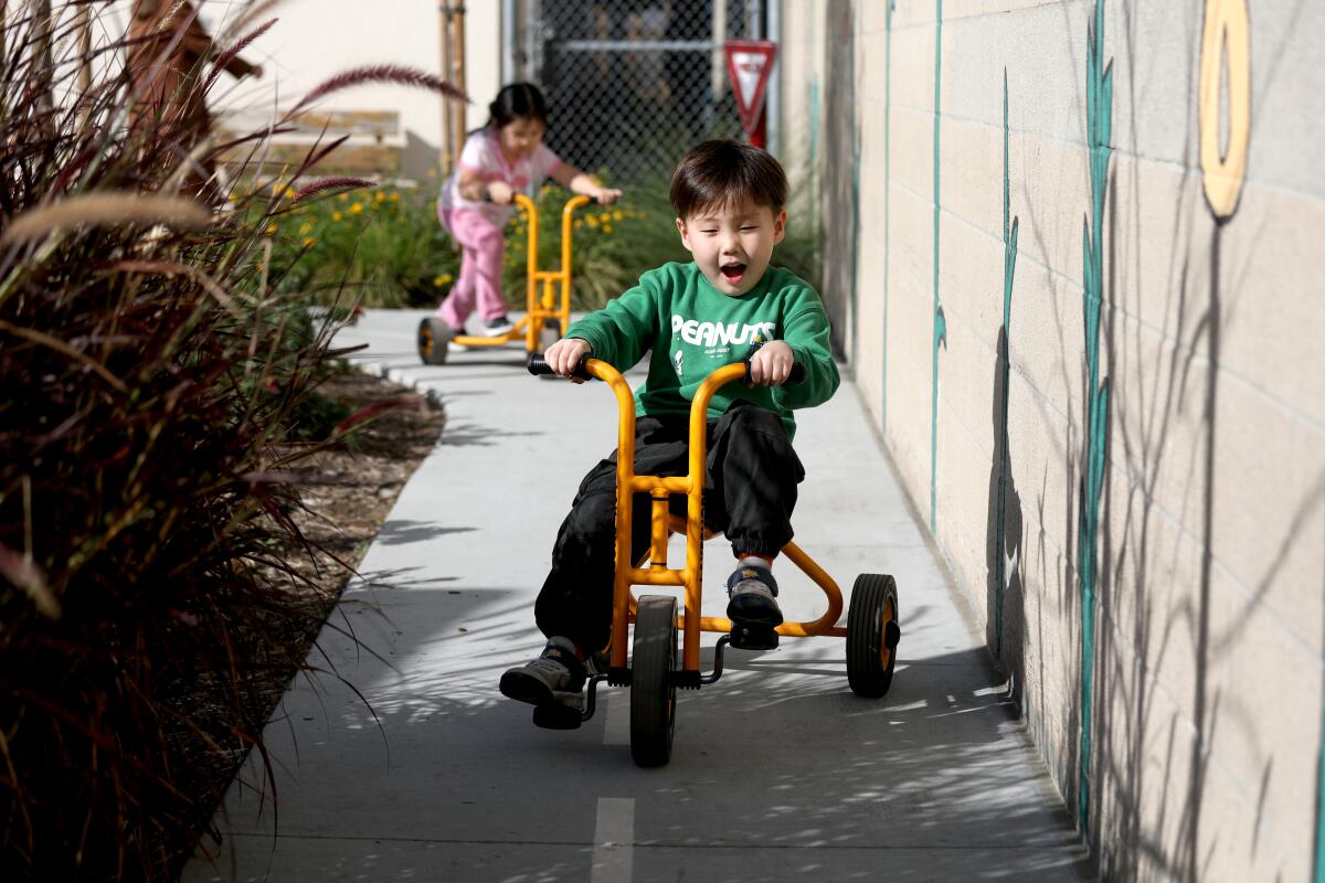 A boy rides a tricycle. 
