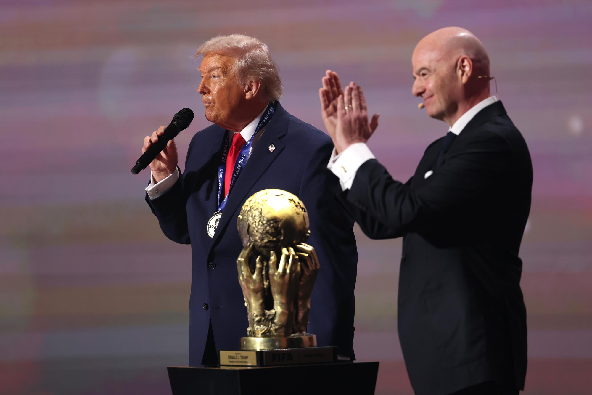 President Trump speaks as he receives the FIFA Peace Prize while FIFA president Gianni Infantino applauds Friday.