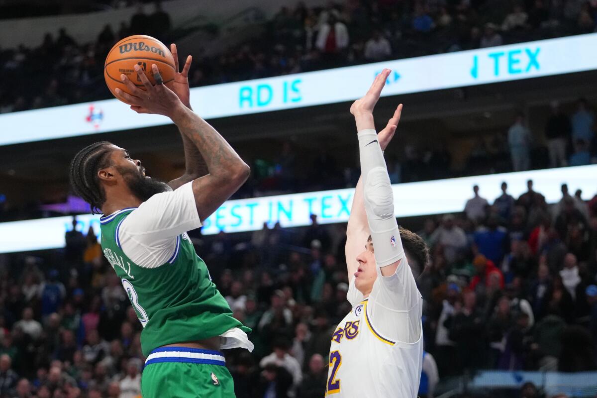 Mavericks forward Naji Marshall, left, pulls up for a jump shot against Lakers forward Jake LaRavia on Saturday