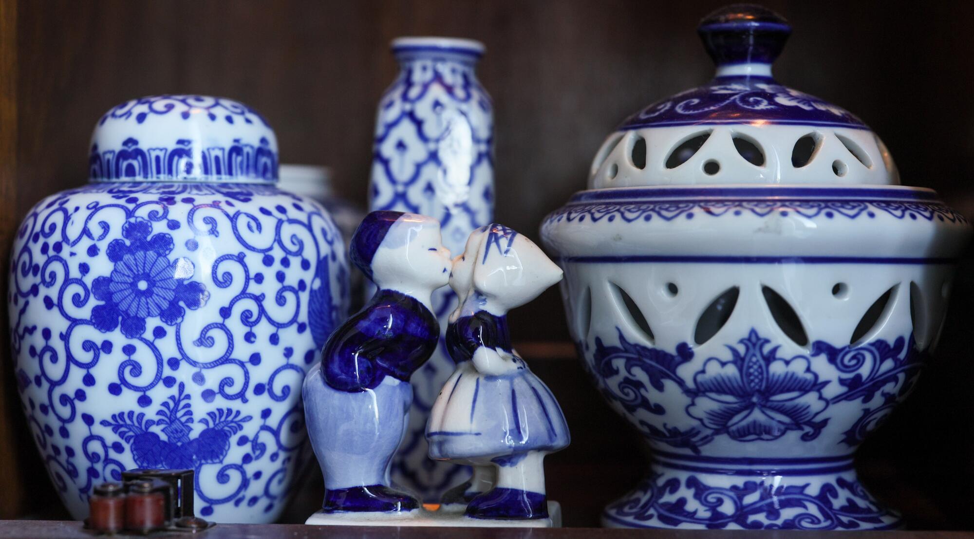 Blue and white vintage fine china items sit in display case.