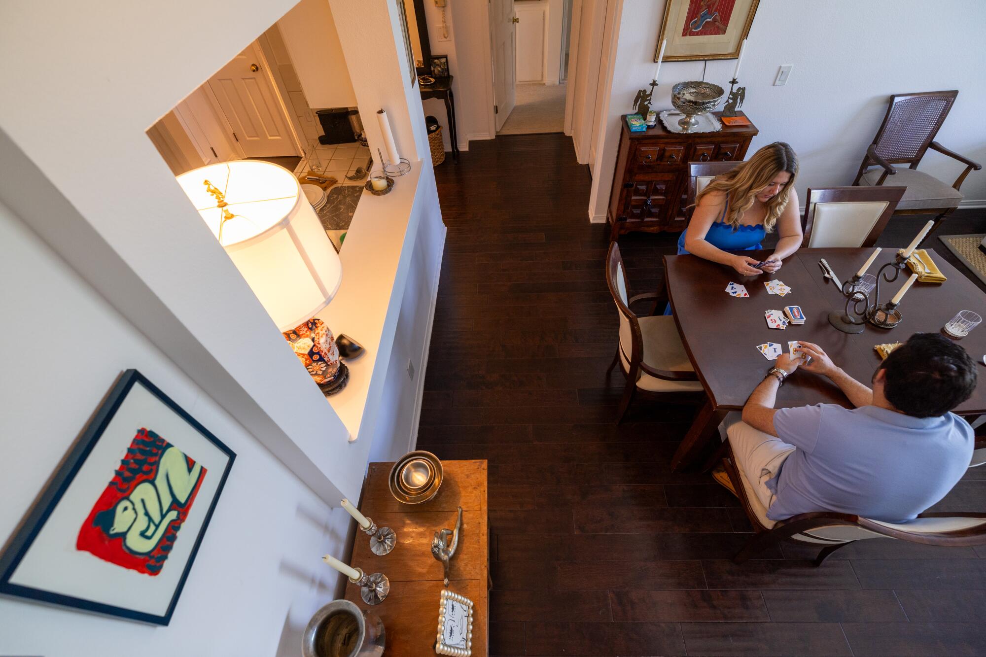 Tess van Hulsen and Andrew Chait play cards inside their rental condo.