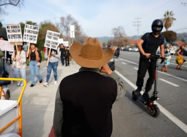 A street vender watches as Overfelt High School students and some community members leave the high school as they protest U.S. Immigration and Customs Enforcement in San Jose, Calif., on Wednesday, Jan. 28, 2026. (Nhat V. Meyer/Bay Area News Group)