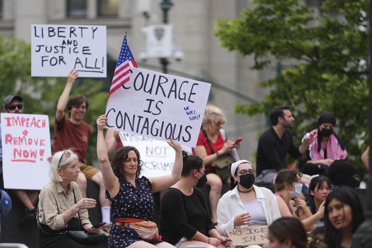 Demonstrators hold signs during a protest against deportation by Immigration and Customs Enforcement.