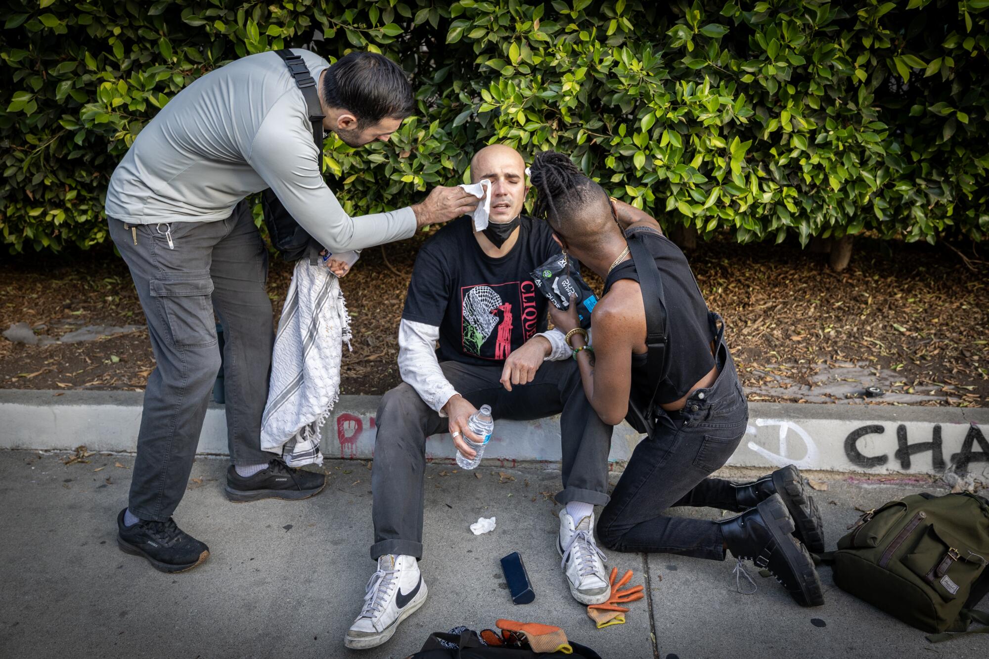 People tend to a protester who held onto the hood of a van driven by federal agents.