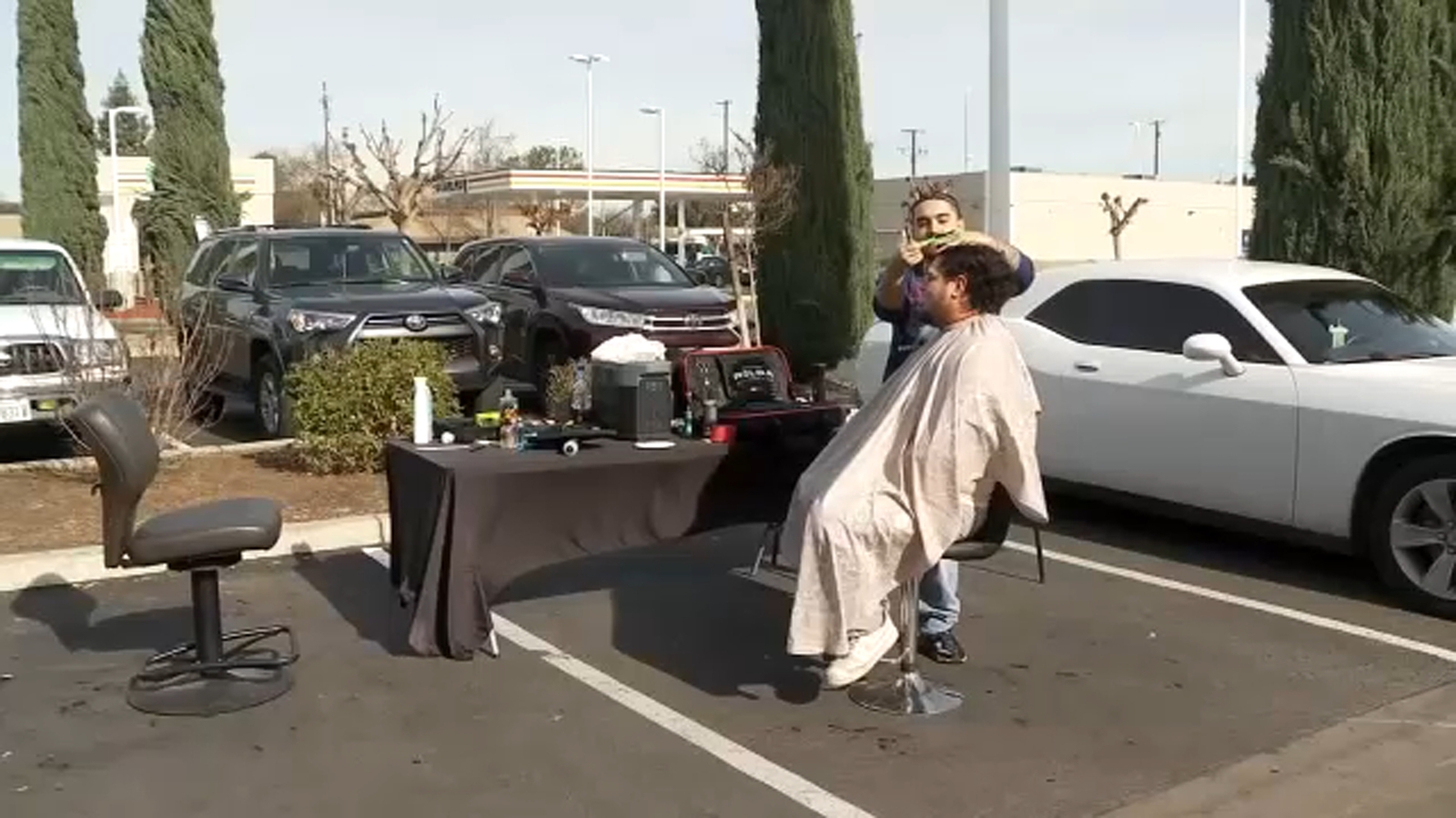 Barbers offer parking lot haircuts after flood shuts down their shop