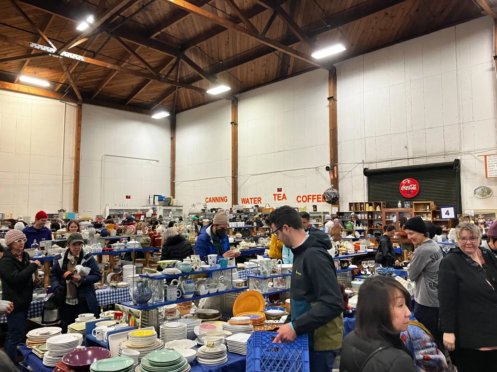 Tall-ceilinged room of shoppers looking at kichenware.