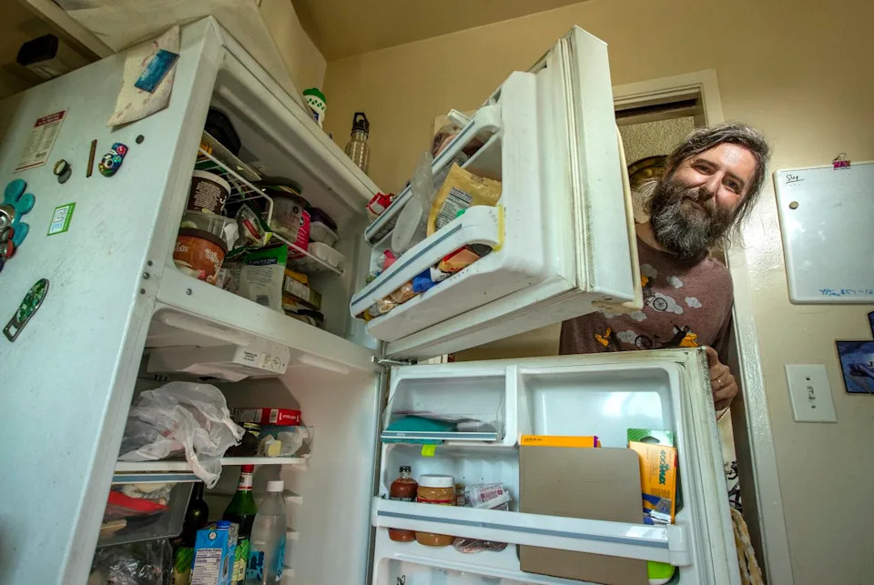 Josh Steichmann, 43, is photographed next to his refrigerator