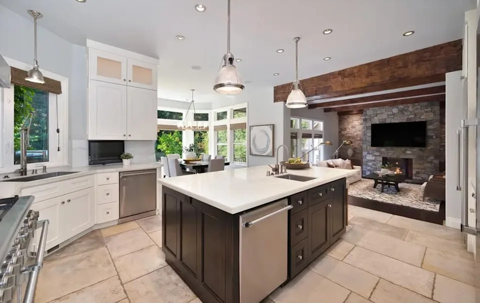 Sunlit and sophisticated, the gourmet kitchen features Carrara marble counters and a light-filled breakfast nook.
