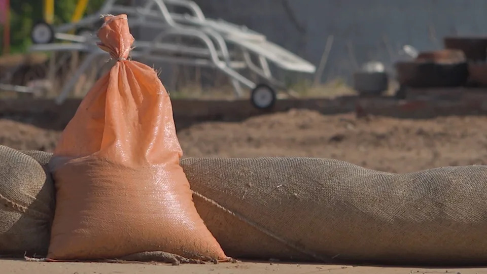 A sandbag sits at a construction site where a home is being rebuilt after a wildfire.