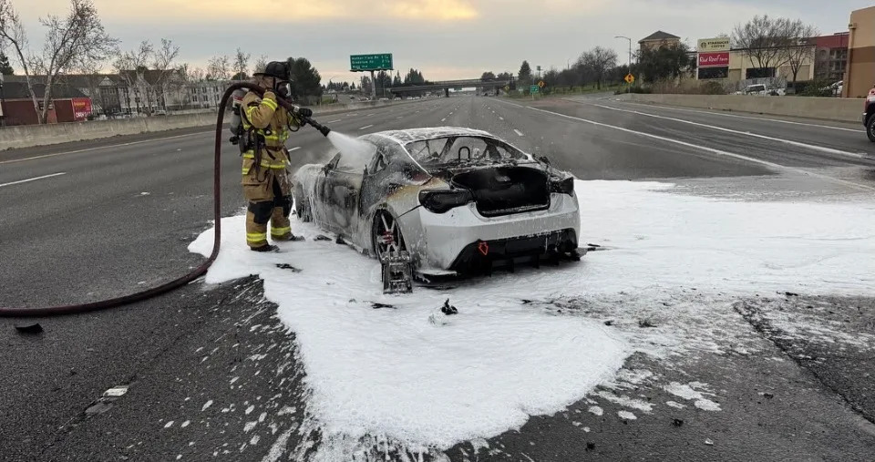 <em>A firefighter is putting out the fire from the vehicle./ Image: CHP East Sacramento</em>