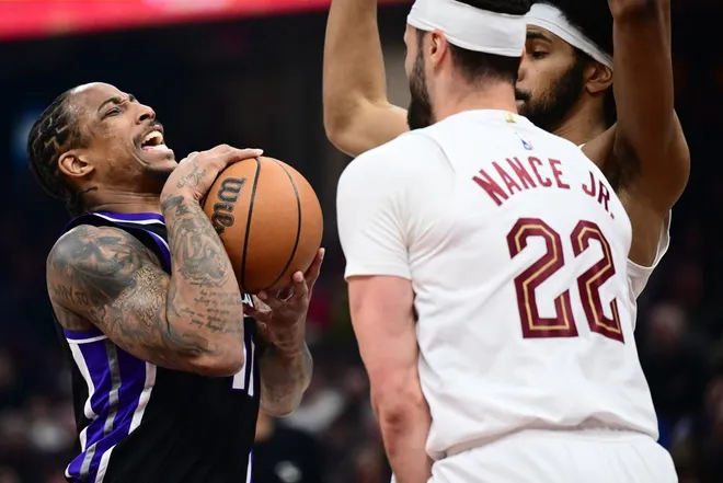 Jan 23, 2026; Cleveland, Ohio, USA; Sacramento Kings guard DeMar DeRozan (10) drives to the basket against Cleveland Cavaliers forward Larry Nance Jr. (22) and center Jarrett Allen (31) during the first half at Rocket Arena.
