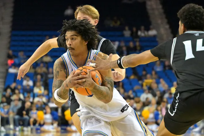 Dec 19, 2025; Los Angeles, California, USA; UCLA Bruins guard Skyy Clark (55) is defended by Cal Poly Mustangs forward Troy Plumtree (13) and guard Cayden Ward (14) as he drives to the basket during the first half at Pauley Pavilion presented by Wescom Financial.