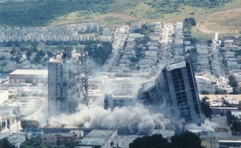 An aerial photo of a large apartment building imploding