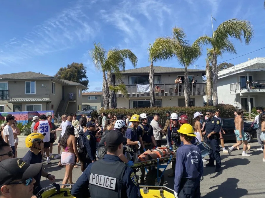 Partygoers crowd a street in Isla Vista while paramedics wheel an injured person on a gurney during the unsanctioned Deltopia party on April 8, 2023 (Santa Barbara County Sheriff's Office)