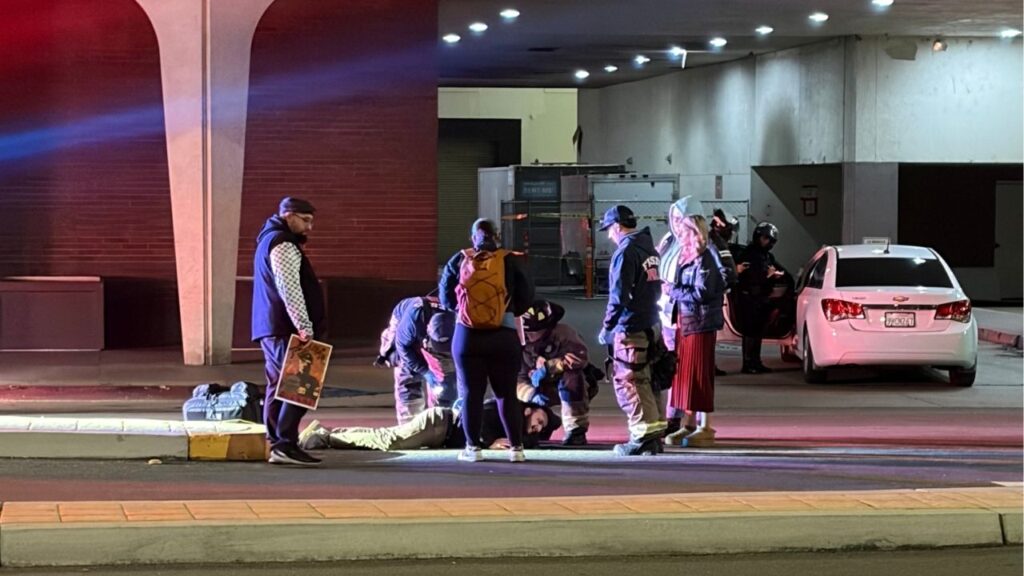 A KSEE24 photojournalist, identified as Jesus Garcia, lays in the road receiving medical attention after being hit by a car at a Thursday, Jan. 9, 2026, protest in downtown Fresno. (GV Wire/Maryanne Casas-Perez)