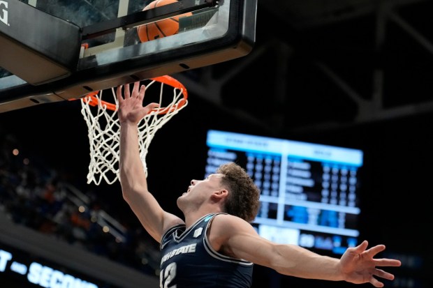 Utah State guard Mason Falslev (12) makes a basket against UCLA during the first half in the first round of the NCAA college basketball tournament, Thursday, March 20, 2025, in Lexington, Ky. (AP Photo/Brynn Anderson)