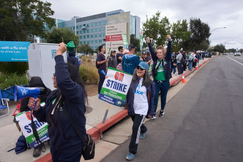 People holding signs striking outside a medical center.