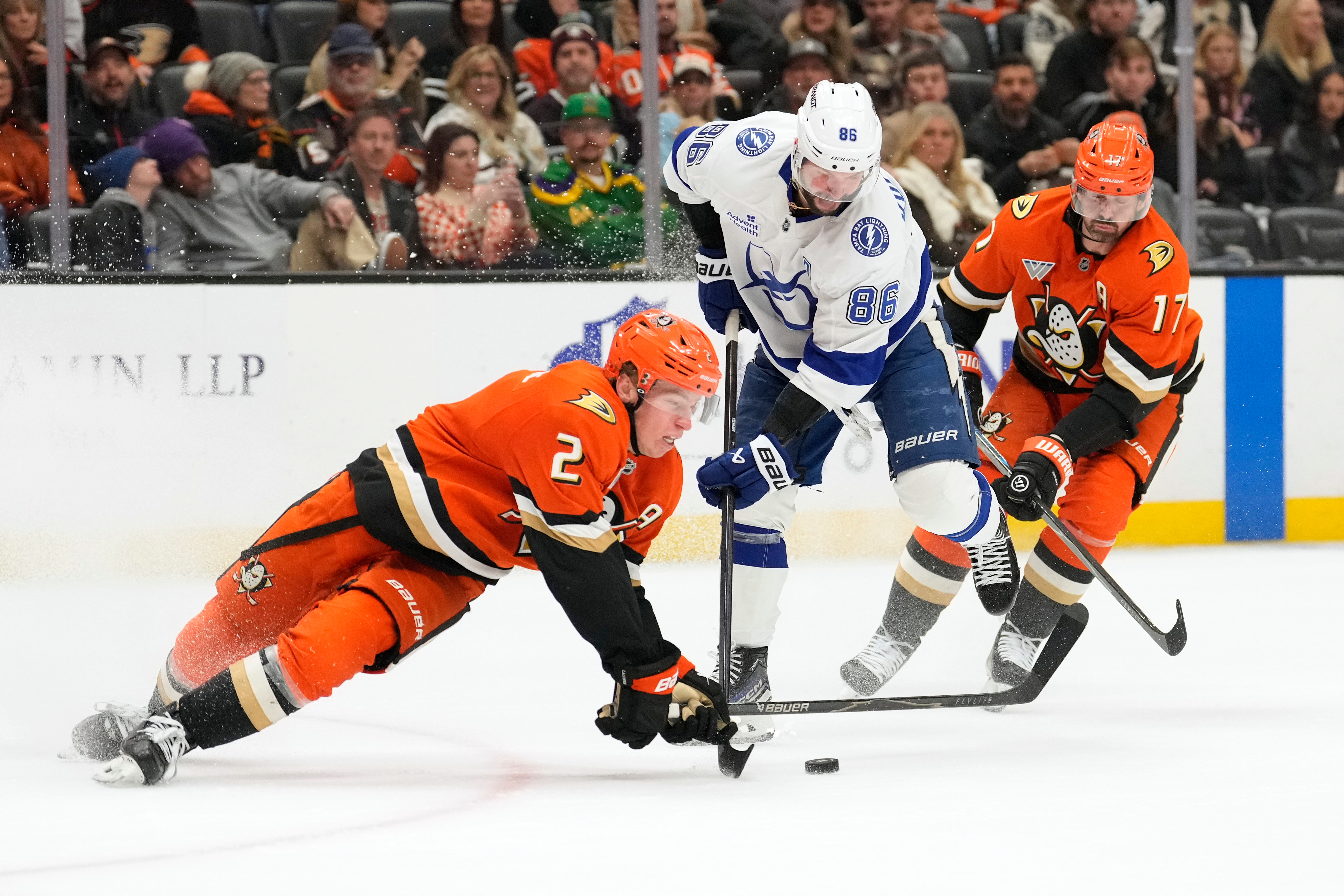 Ducks defenseman Jackson Lacombe, left, falls to the ice as...